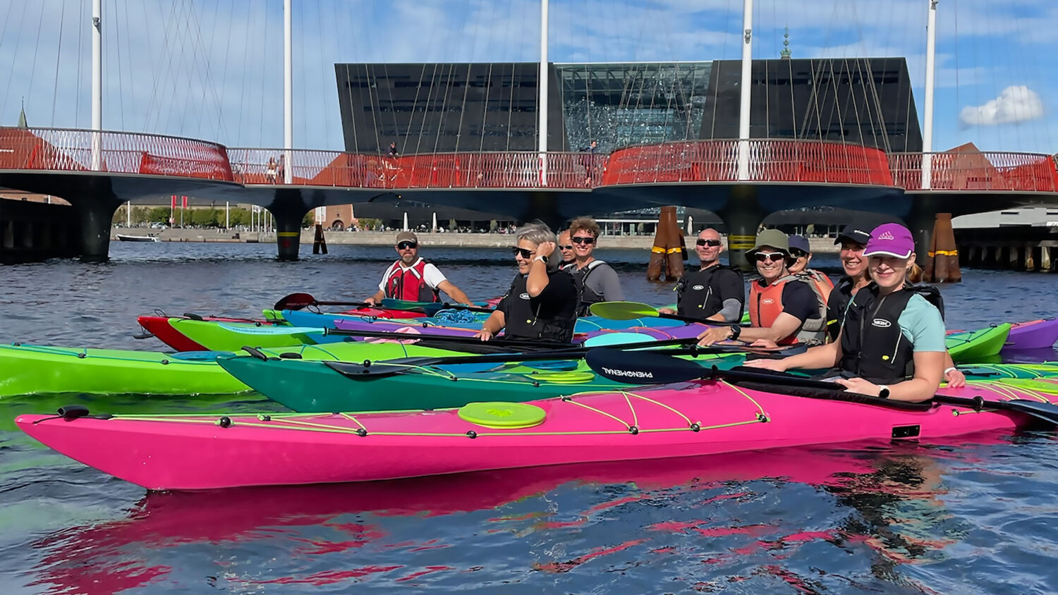 designkayaks herobillede til story om at komme ud i kajak efter IPP2 kursus. billedet viser glade medlemmer af Social Paddling Club på en guidet tur i havkajak i Københavns kanaler